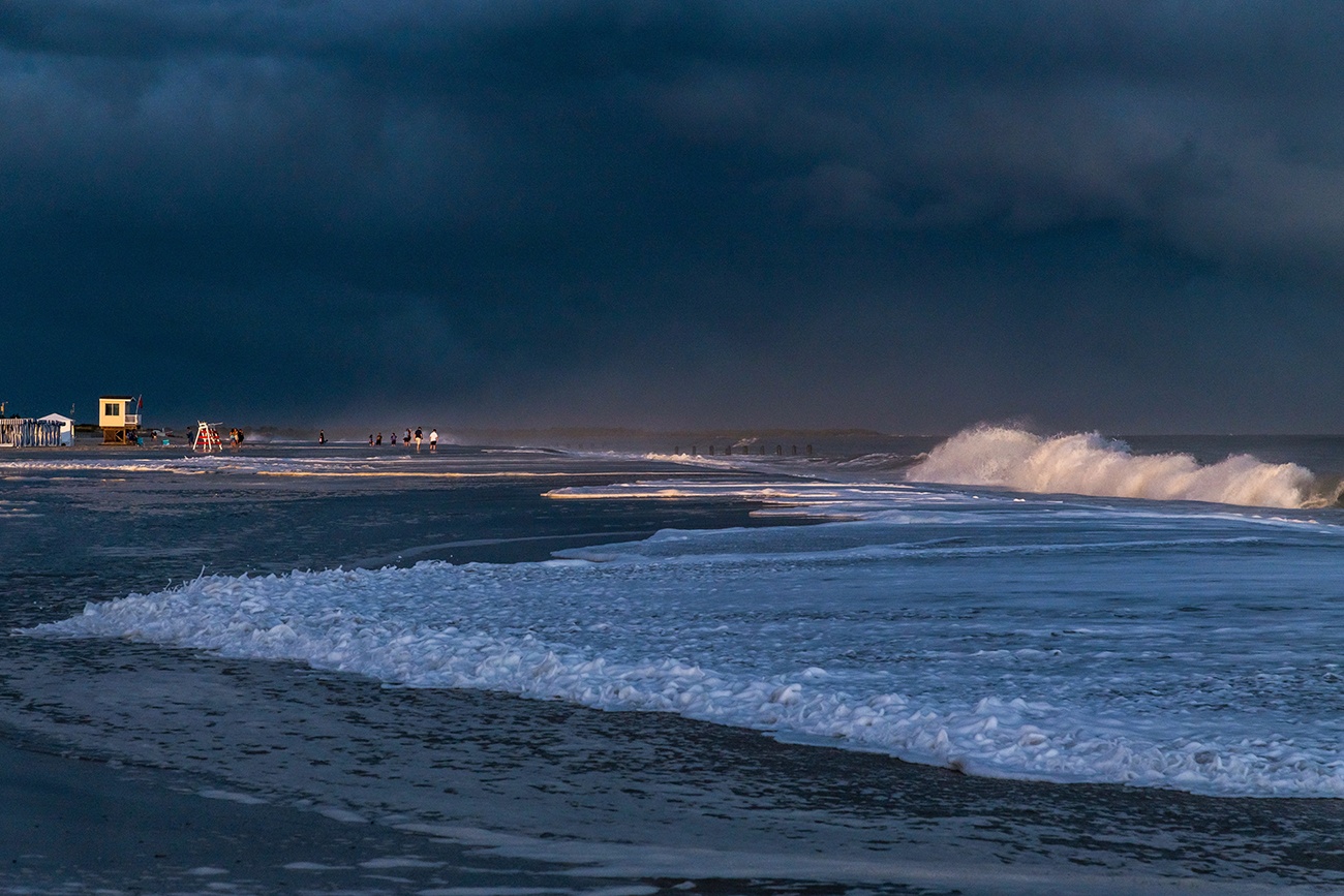 Big waves crashing during an extreme high tide with dark clouds in the sky