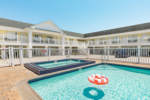 orange float on a swimming pool in front of a two-story motel