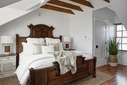 Guest room at the Casablanca, an ornate king size wood bed in a modern white hotel room