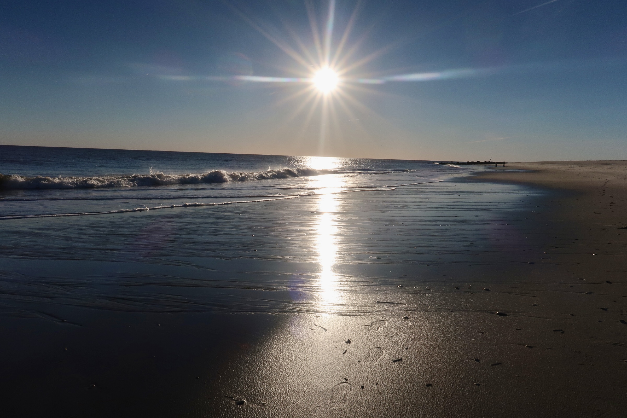 sun reflecting on the water on the beach