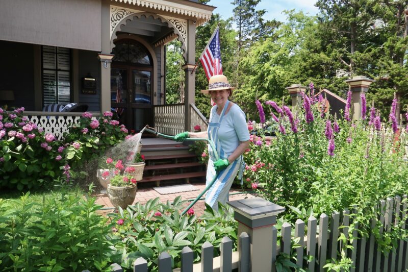 Watering the flower garden at the John Wesley Inn