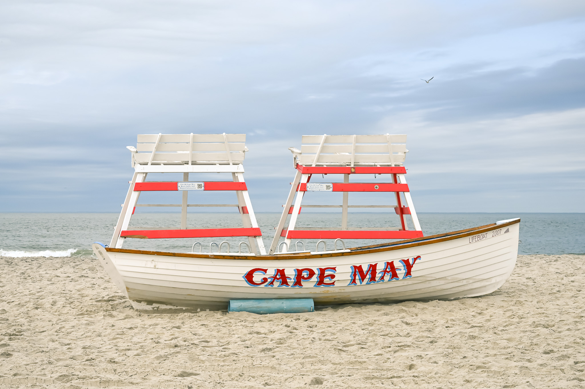 The Beach with two lifeguard stands and a lifeguard boat.